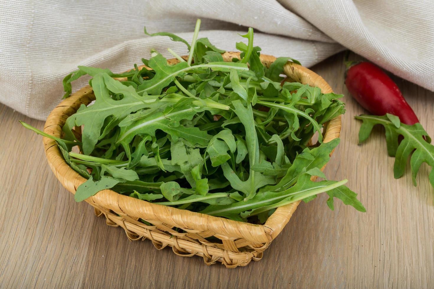 Ruccola in a bowl on wooden background photo