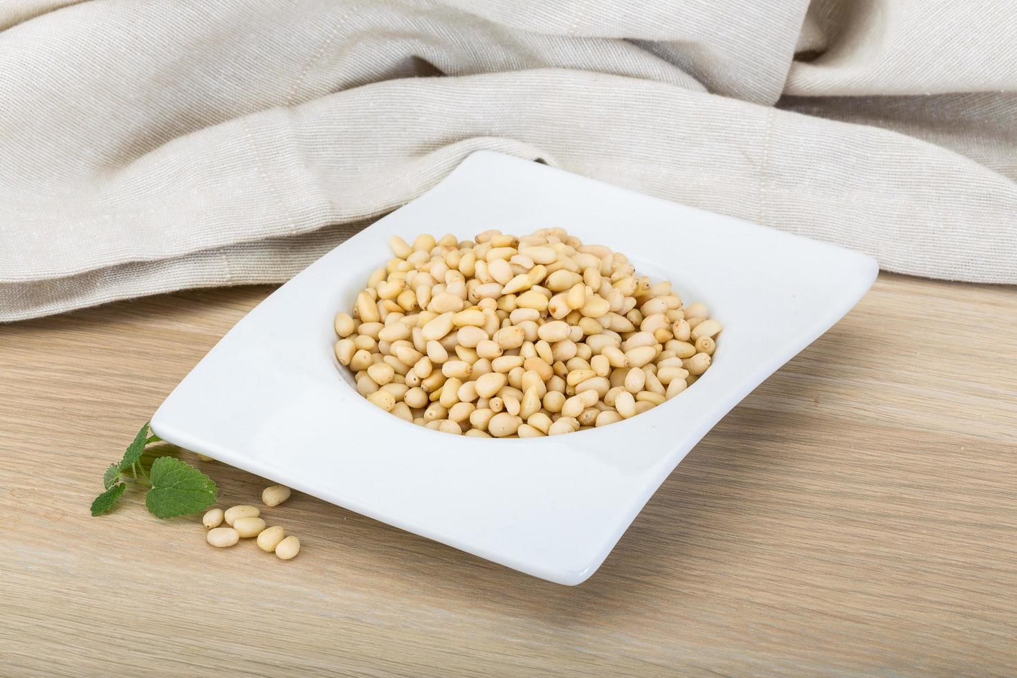 Cedar nut in a bowl on wooden background photo