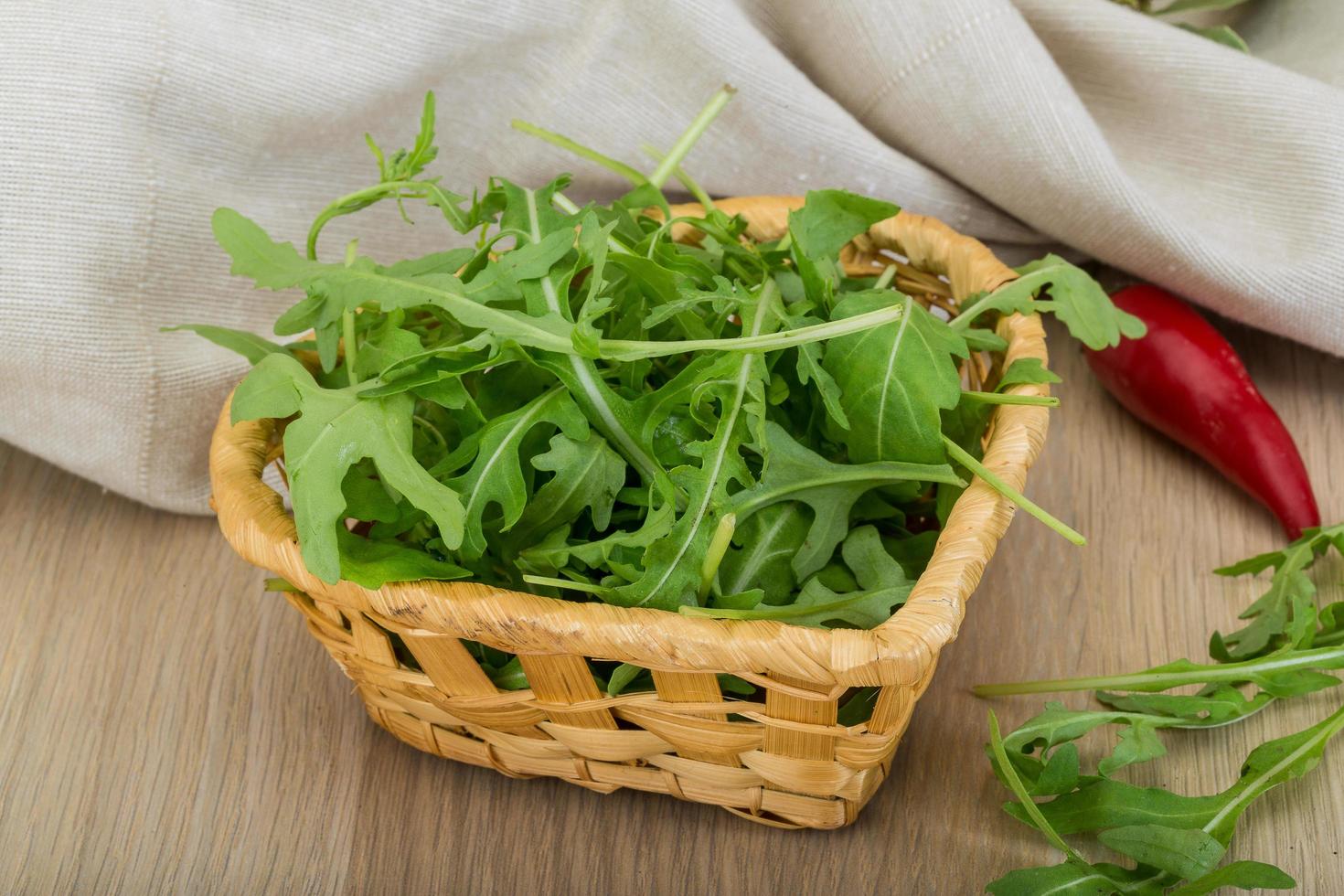 Ruccola in a basket on wooden background photo