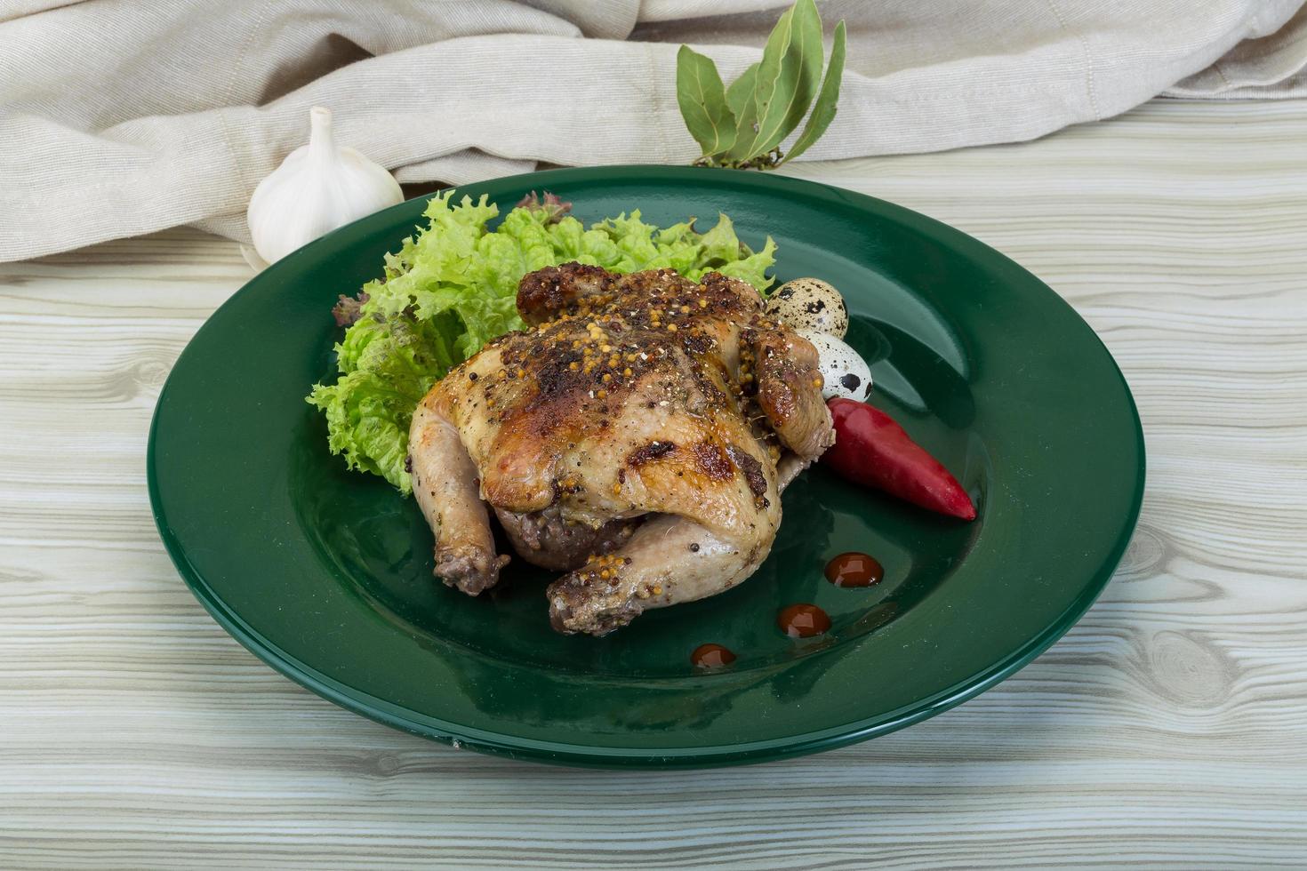 Quail grilled on the plate and wooden background photo