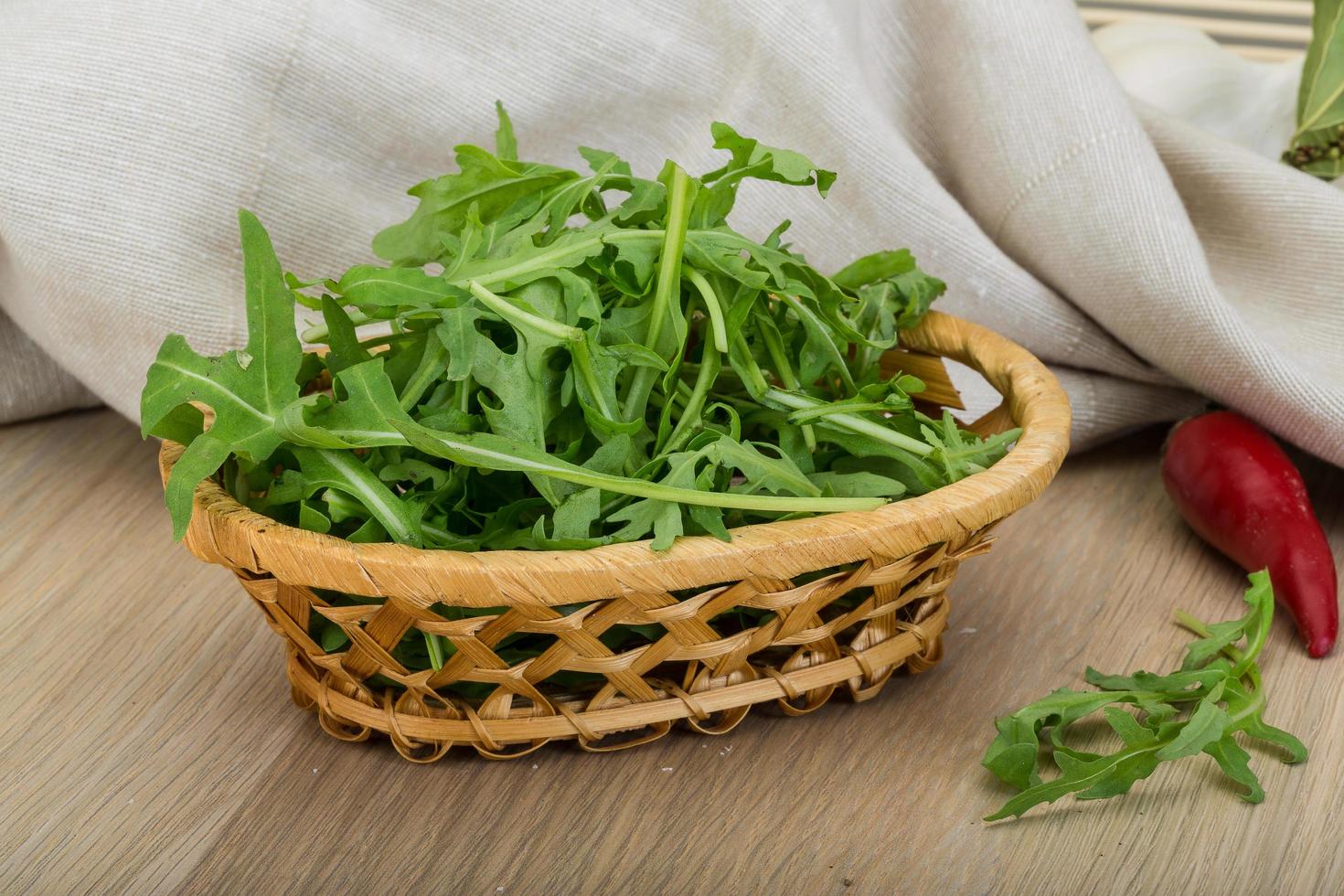 Ruccola in a basket on wooden background photo