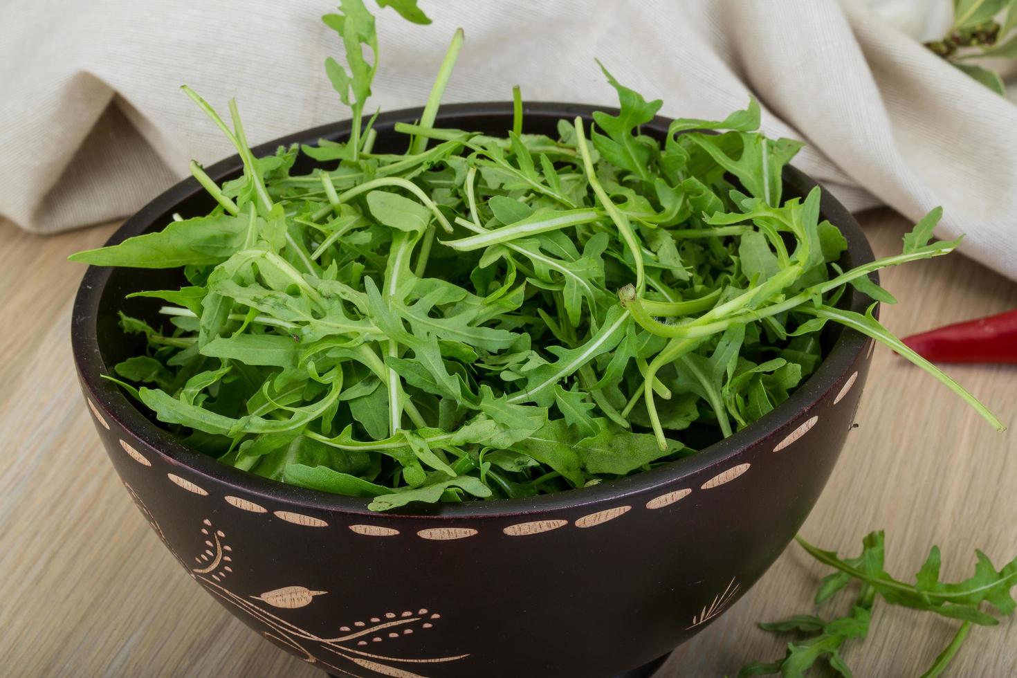 Ruccola in a bowl on wooden background photo