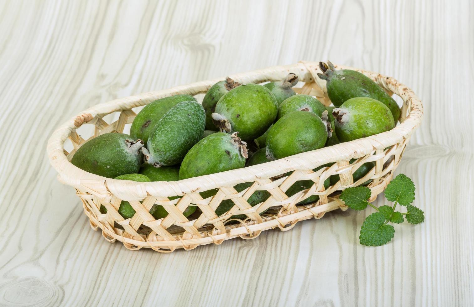 feijoa en una cesta sobre fondo de madera foto