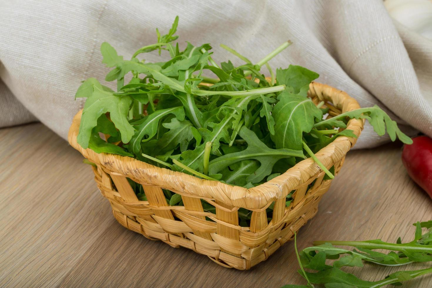 Ruccola in a basket on wooden background photo