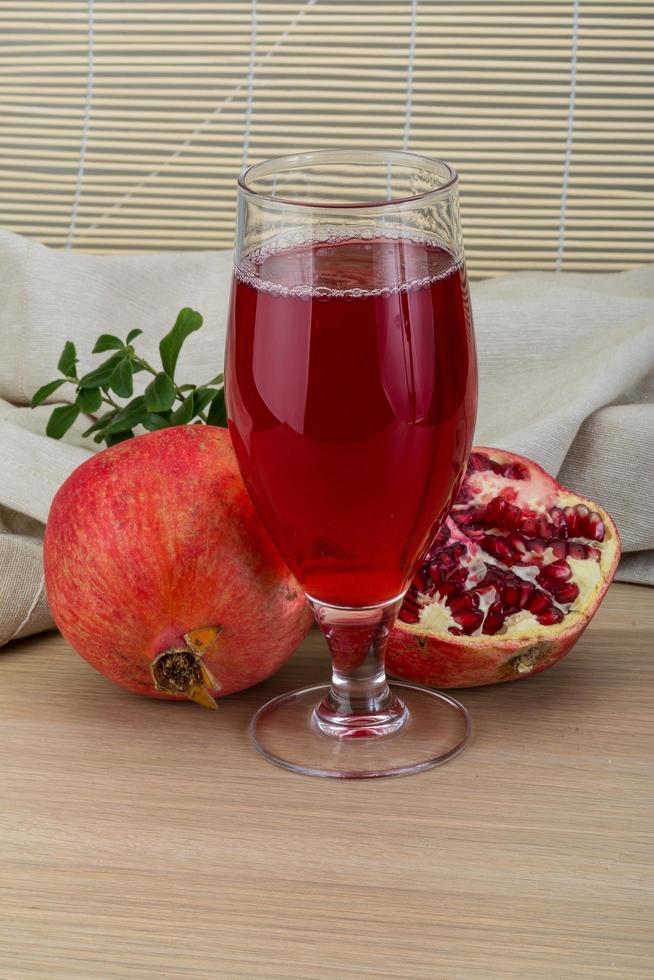 Pomecranet juice on wooden background photo