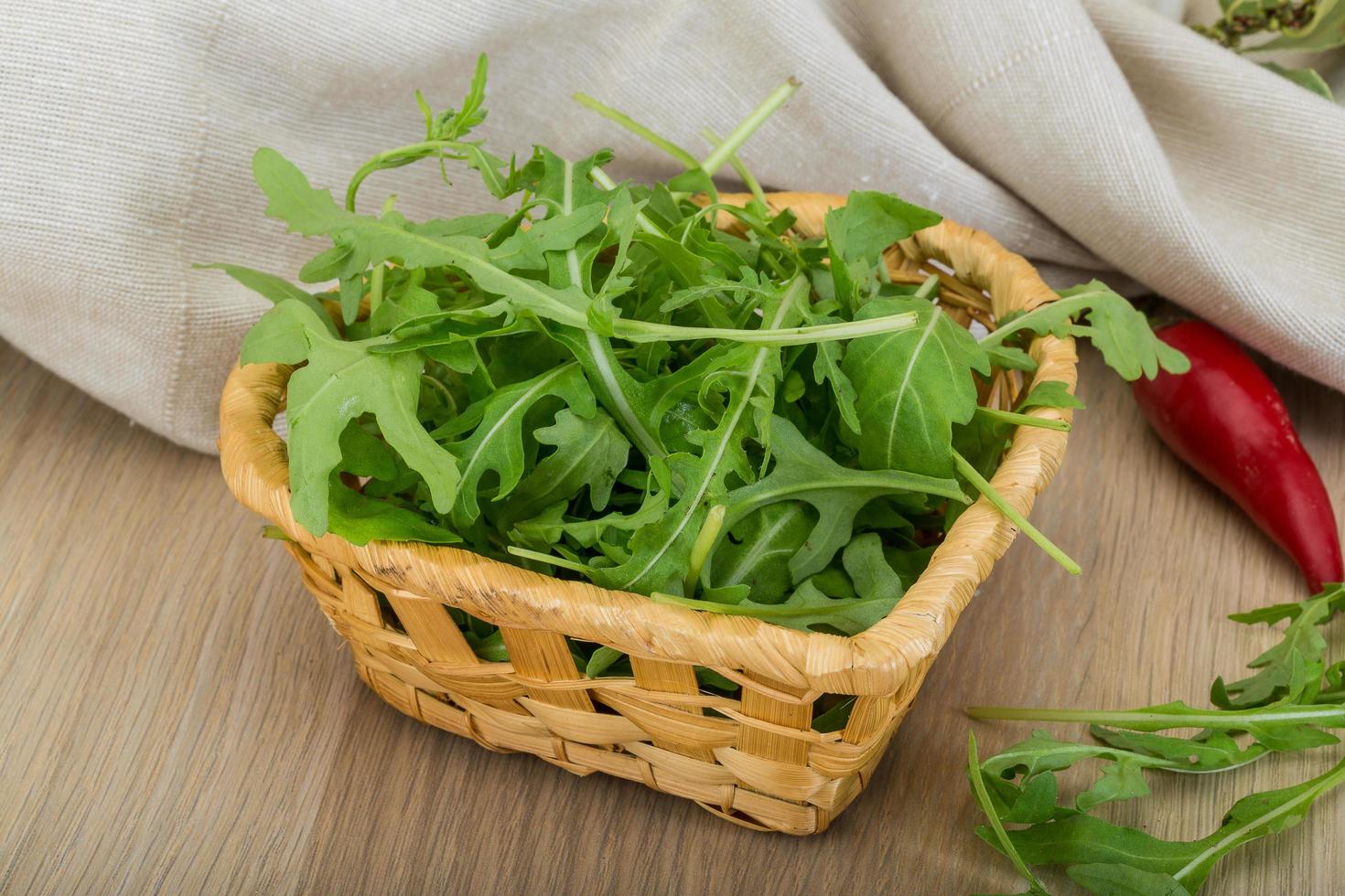 Ruccola in a basket on wooden background photo