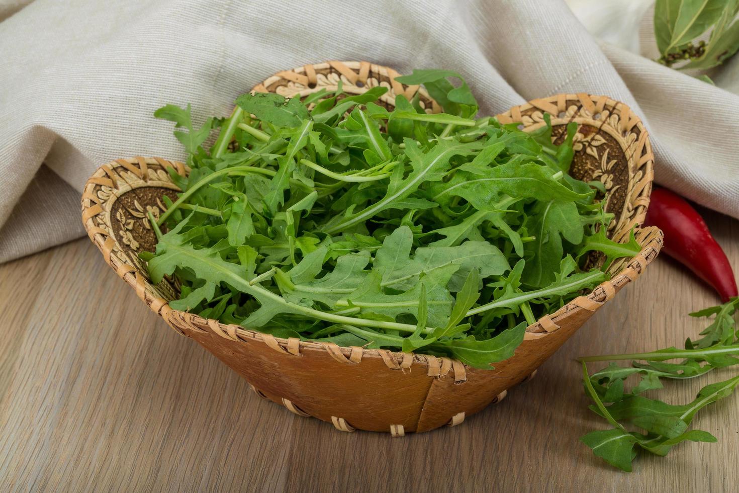 Ruccola in a basket on wooden background photo