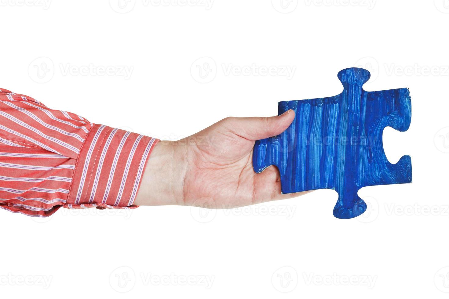 male hand with painted blue puzzle piece photo