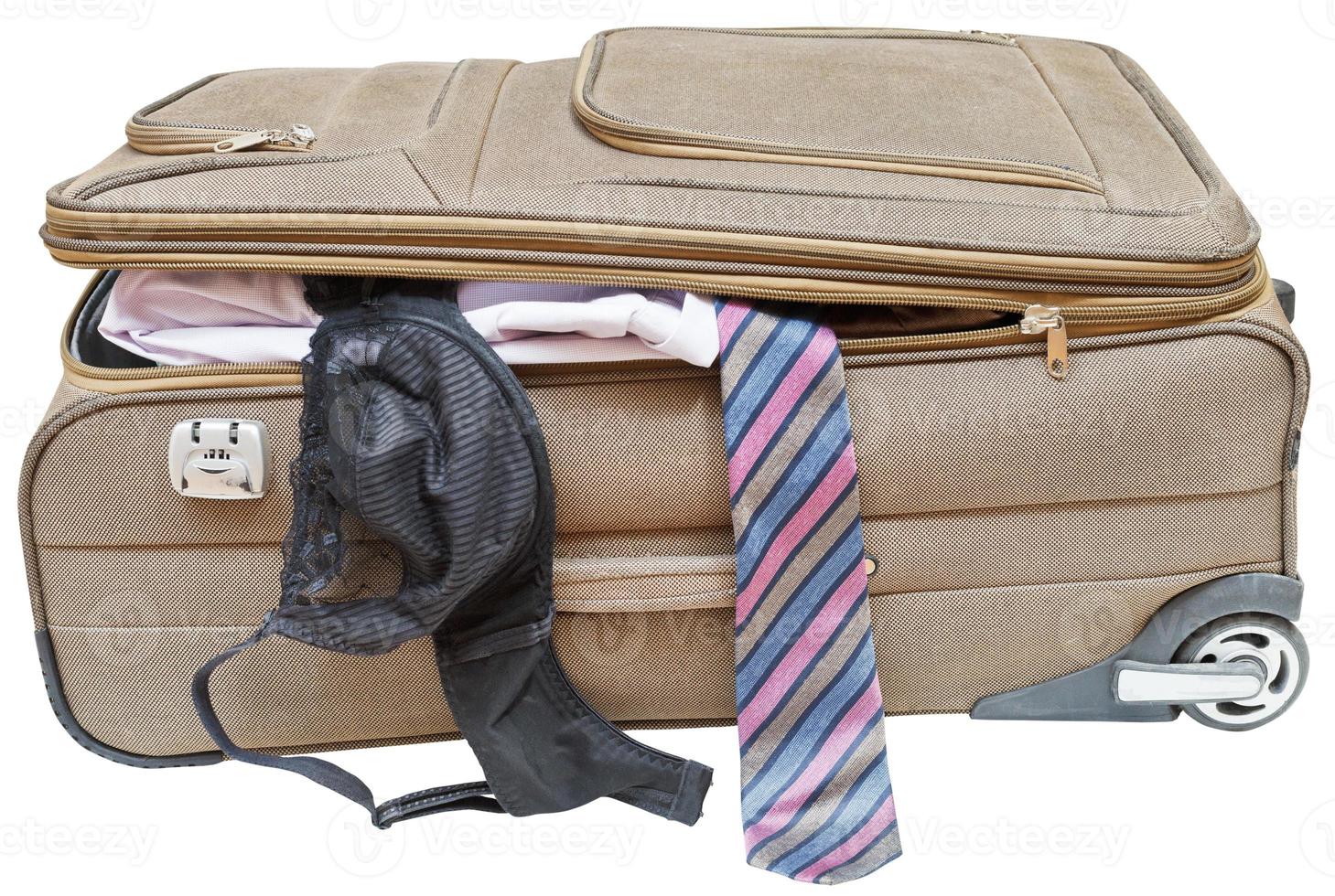 suitcase with fell out male tie and female bra photo