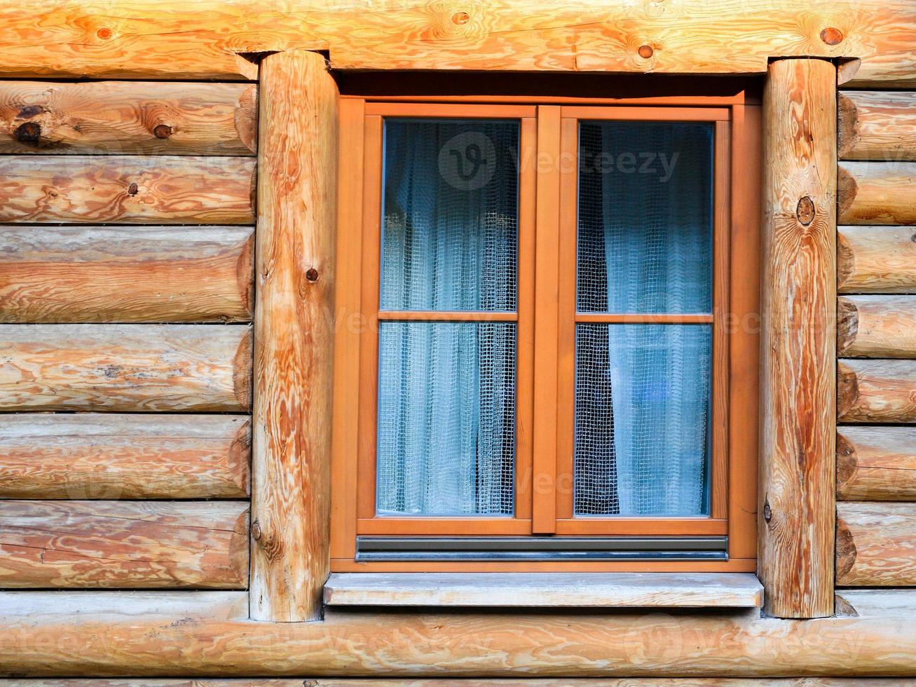 wall with window of modern log house in village photo