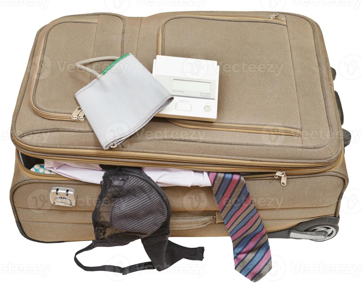 sphygmometer on suitcase with tie and bra photo