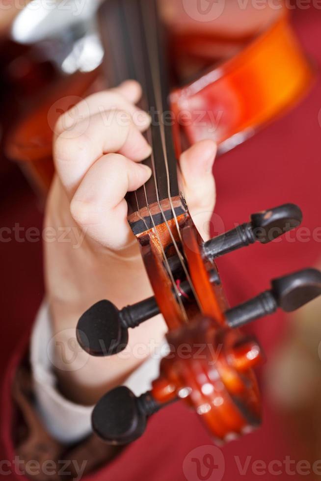 girl plays on fiddle - chord on fingerboard photo
