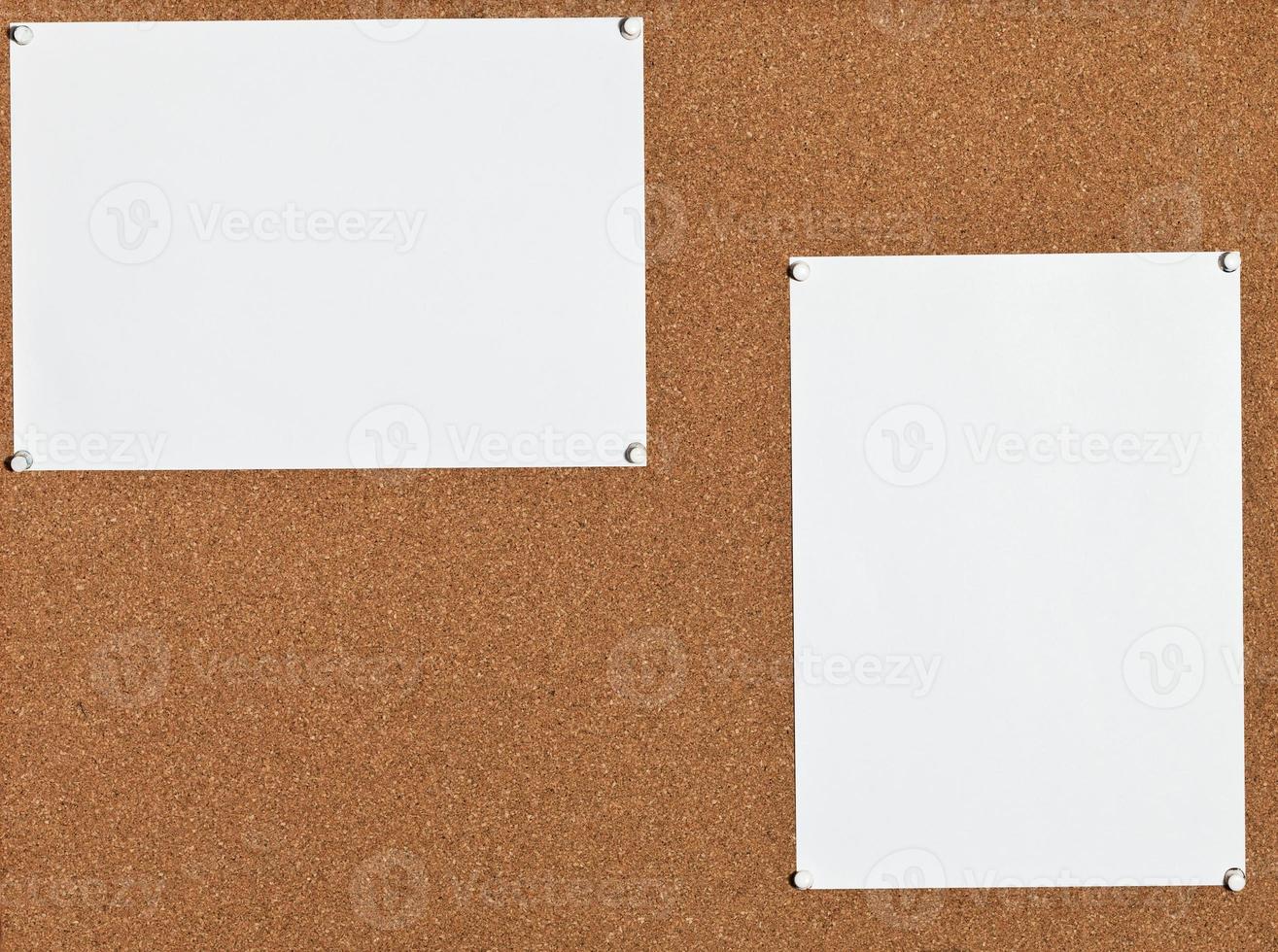 white sheets of paper on cork board photo