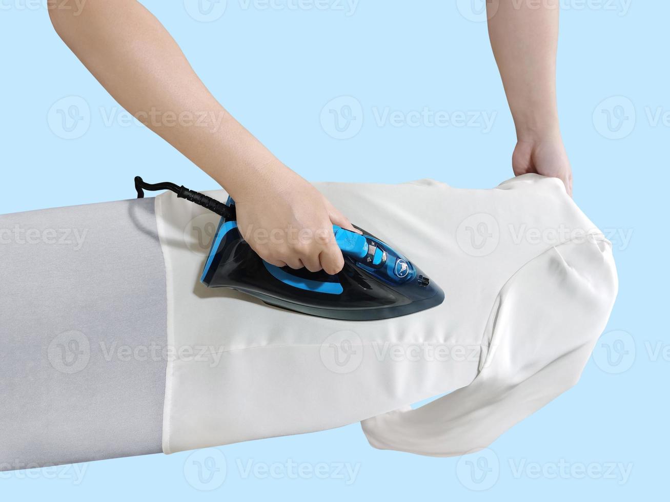 Woman ironing clothes, top view, isolated on blue background. blue iron on white table photo