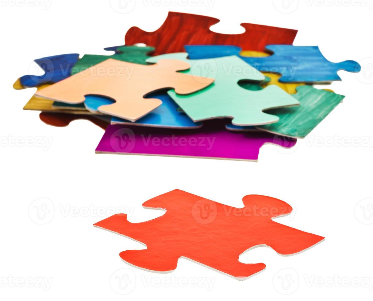 separate piece in front of pile of jigsaw puzzles photo