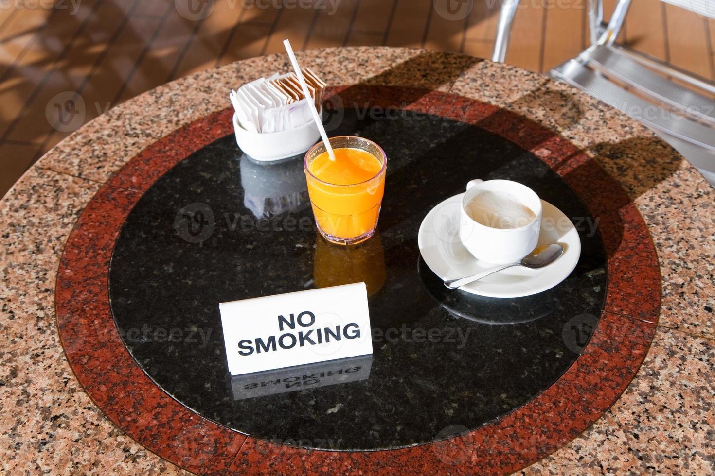 fresh orange juice and cappuccino on no smoking table photo