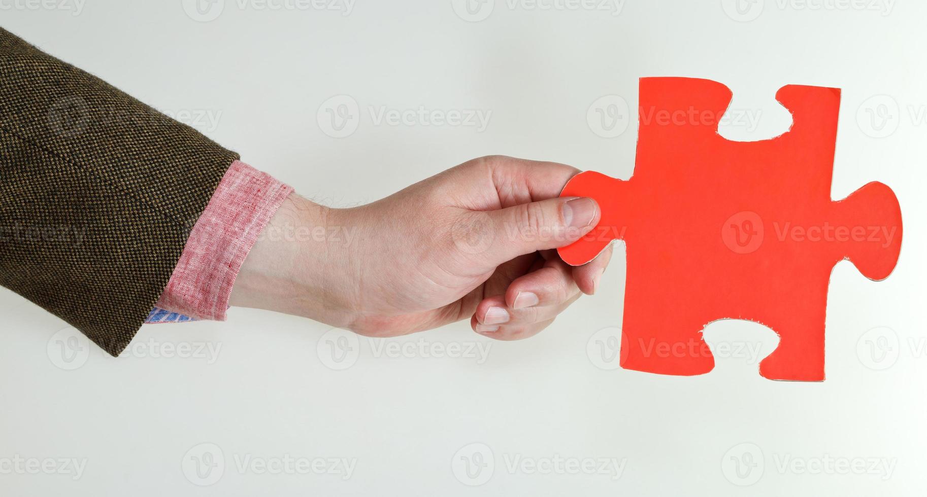 red puzzle piece in male hand photo