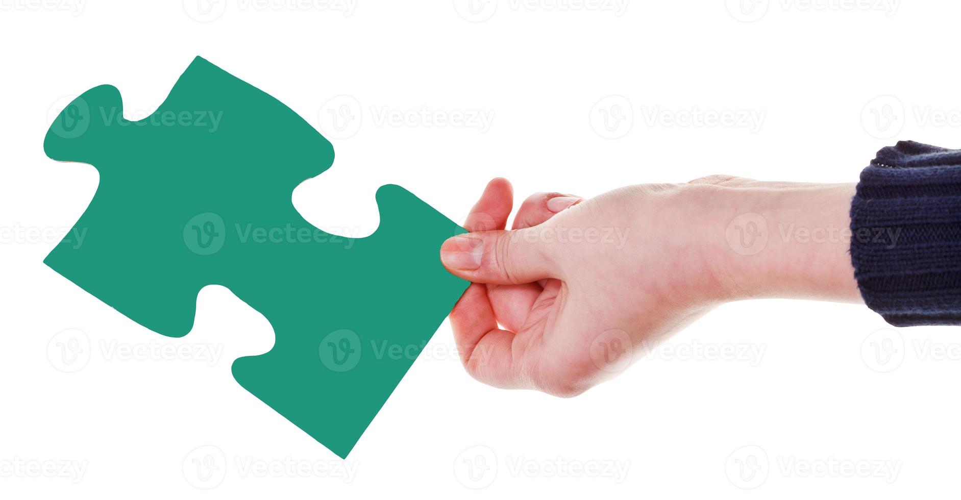 mano femenina con pieza de rompecabezas verde foto