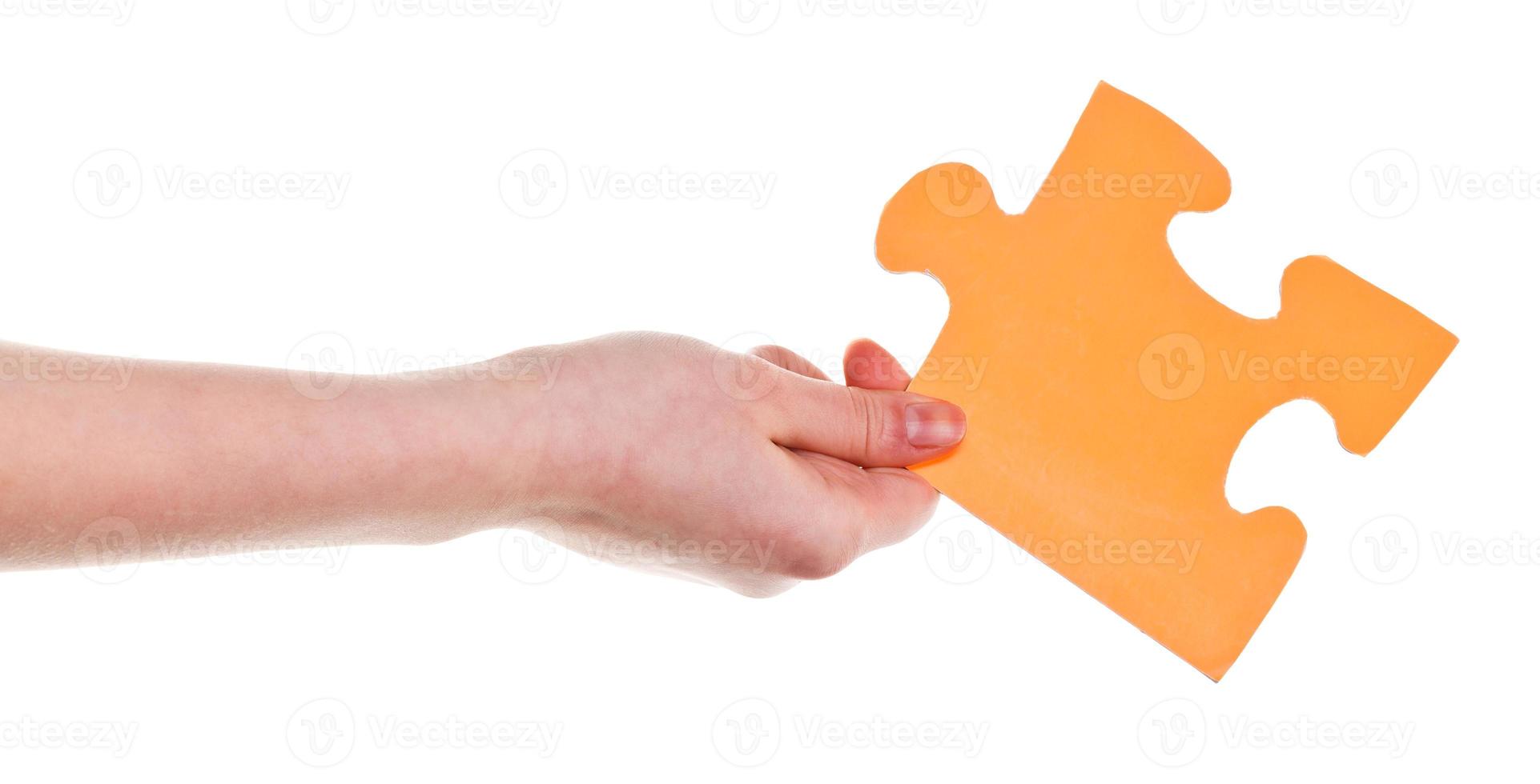 female hand holding big yellow paper puzzle piece photo