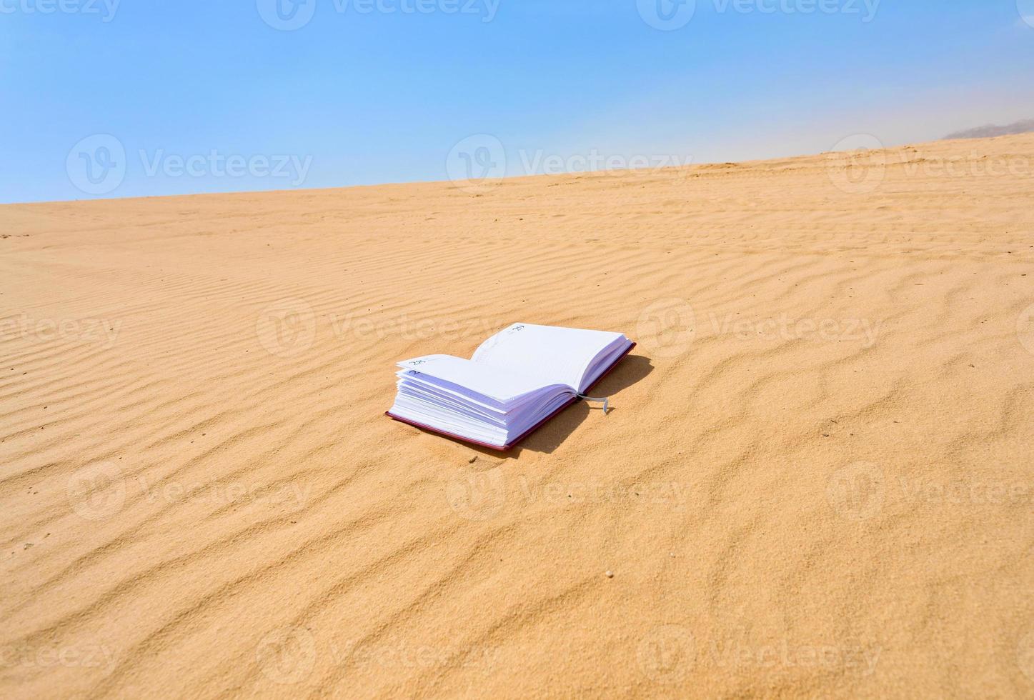 note book in sand dune desert photo