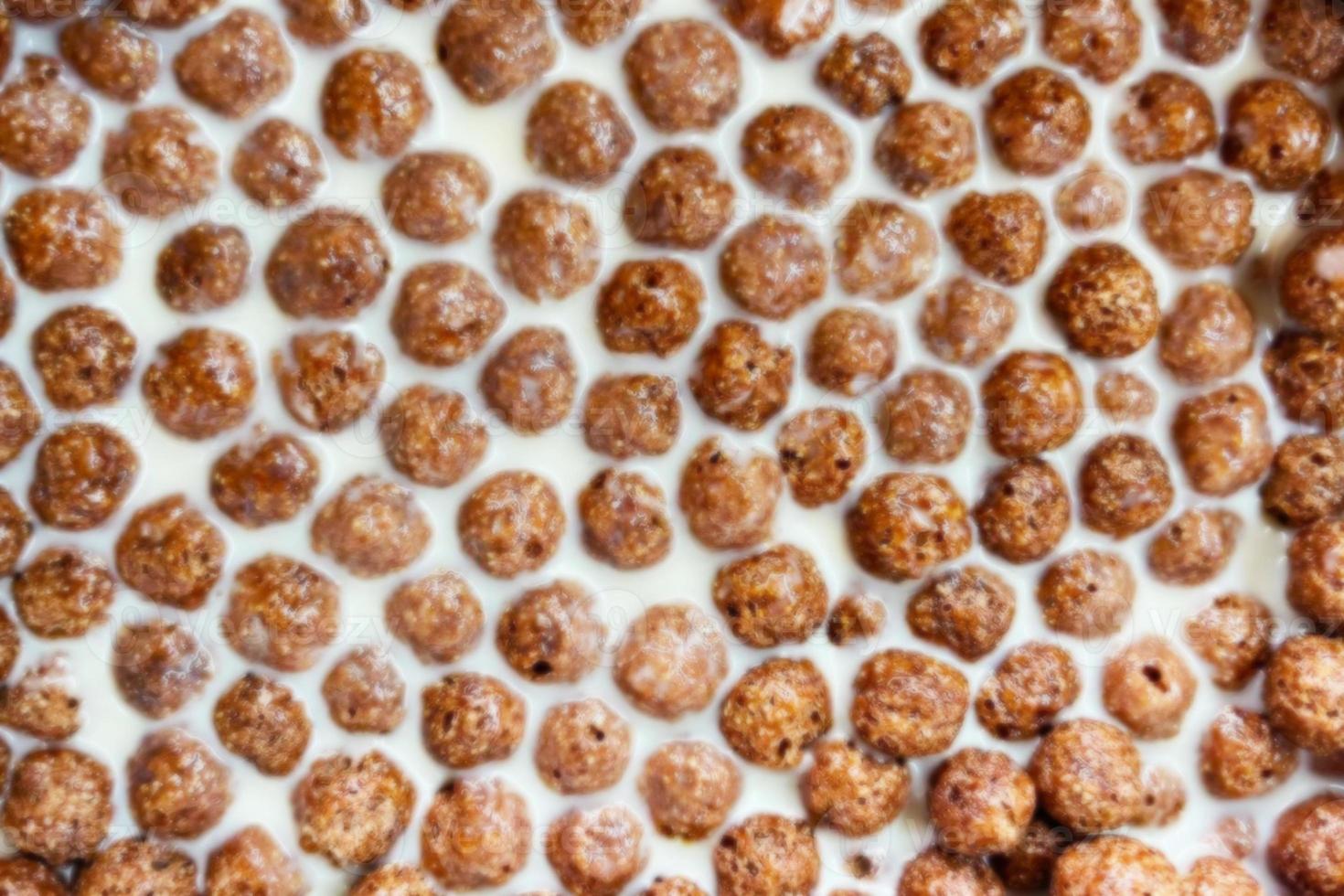 Chocolate corn balls on milk background texture, brown choco cereal balls pattern. healthy sweet snack for breakfast mockup with copy space top view photo