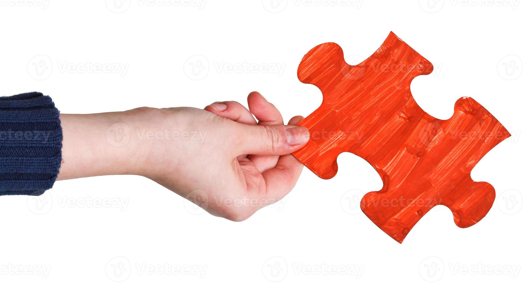 female hand with painted red puzzle piece photo