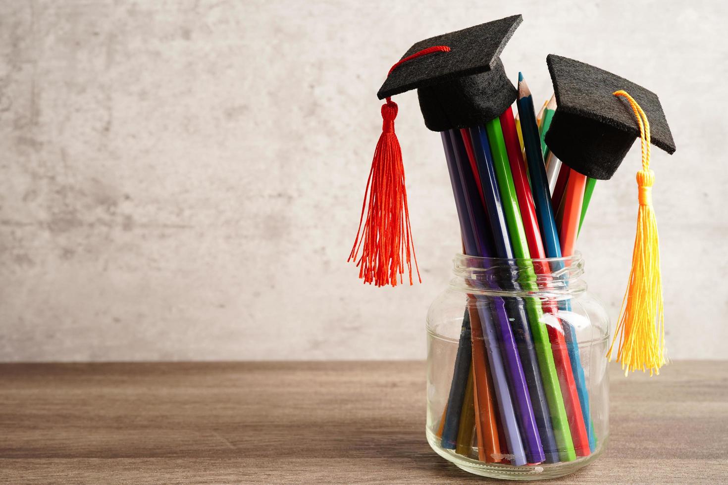 Graduation hat with colorful pencils on book with copy space, learning university education concept. photo