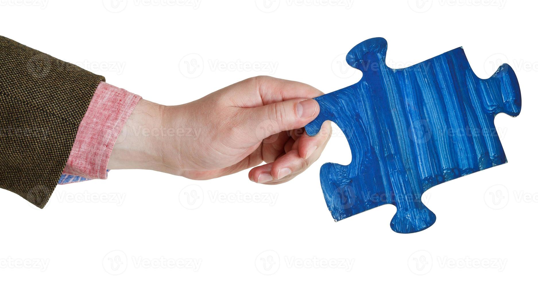 male hand with painted blue puzzle piece photo