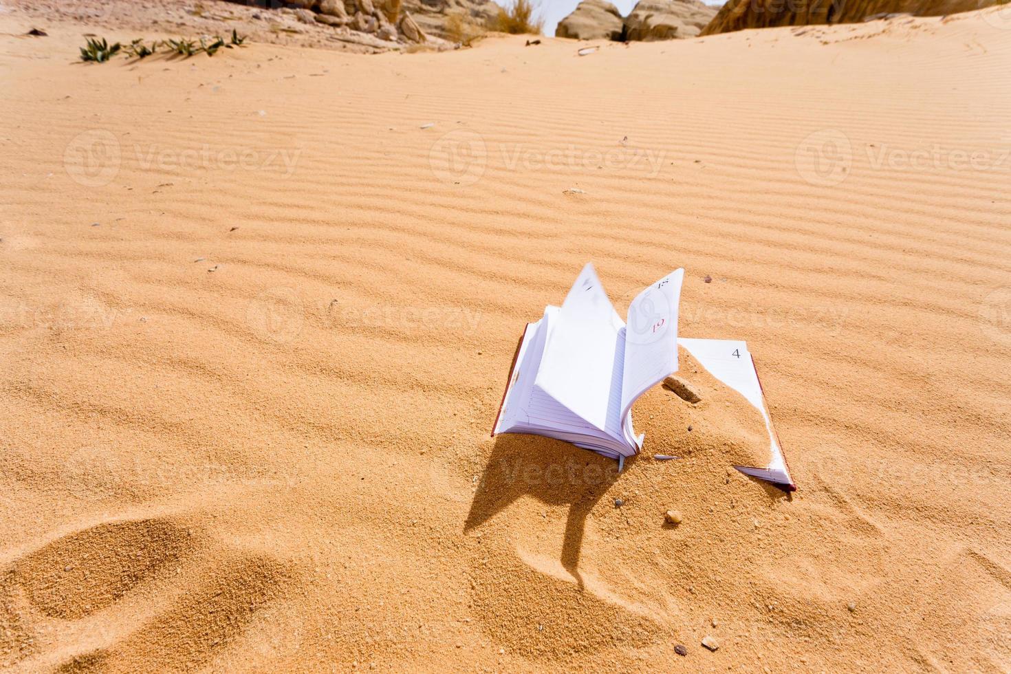 note book in red sand dune of desert photo