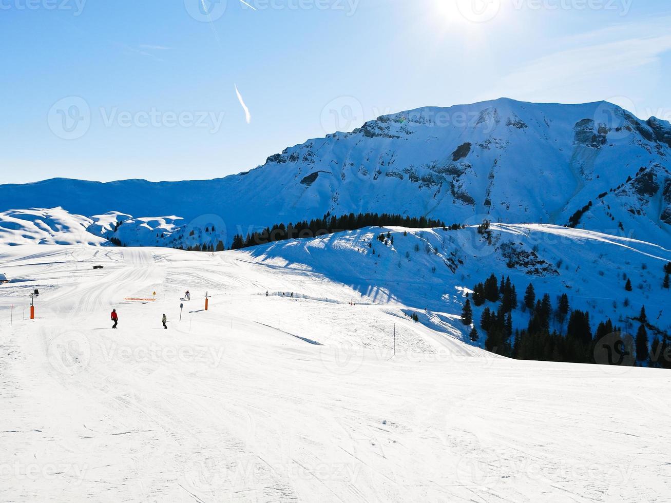 ski run on snow slopes of mountains in sunny day photo