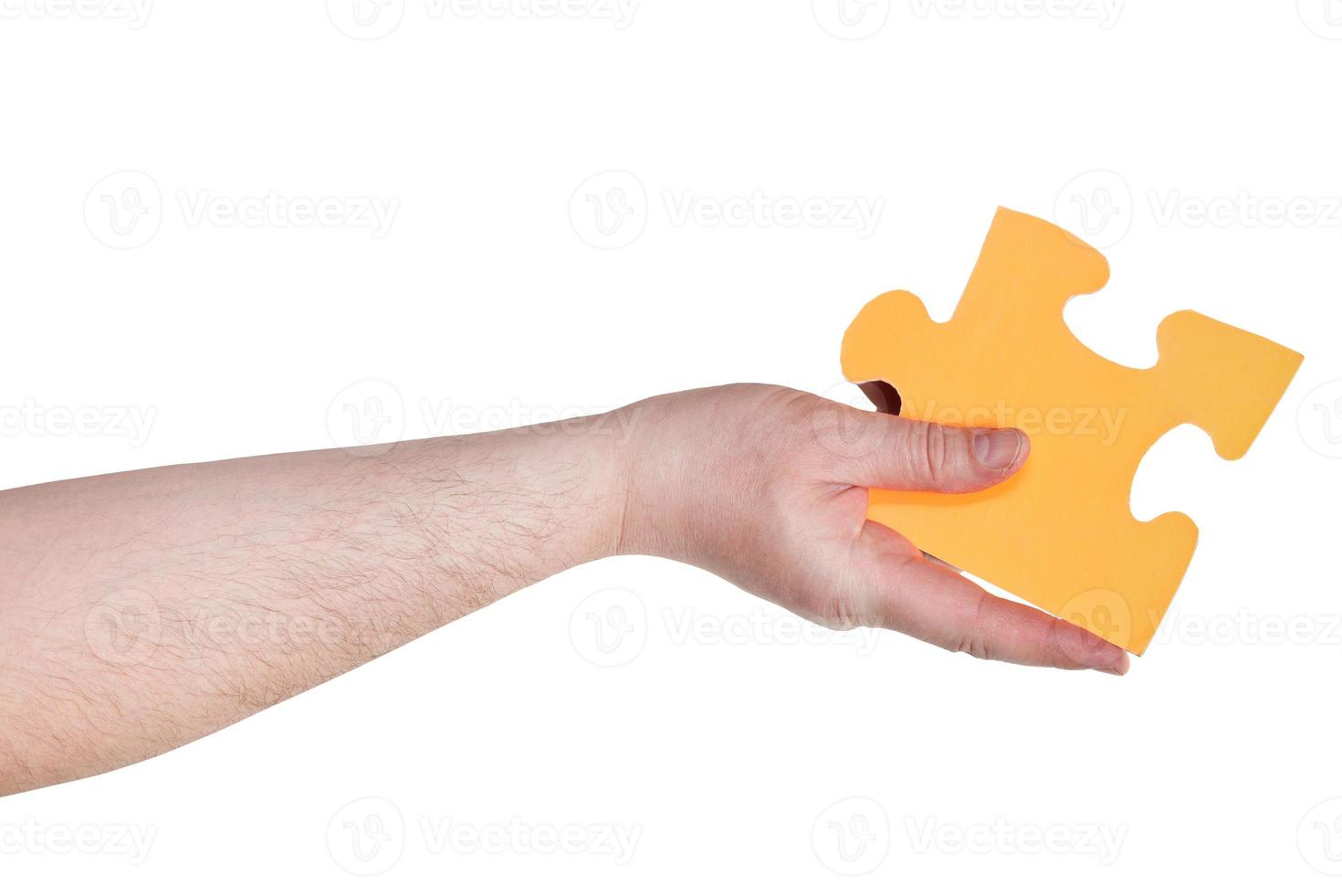 male hand holding big yellow paper puzzle piece photo