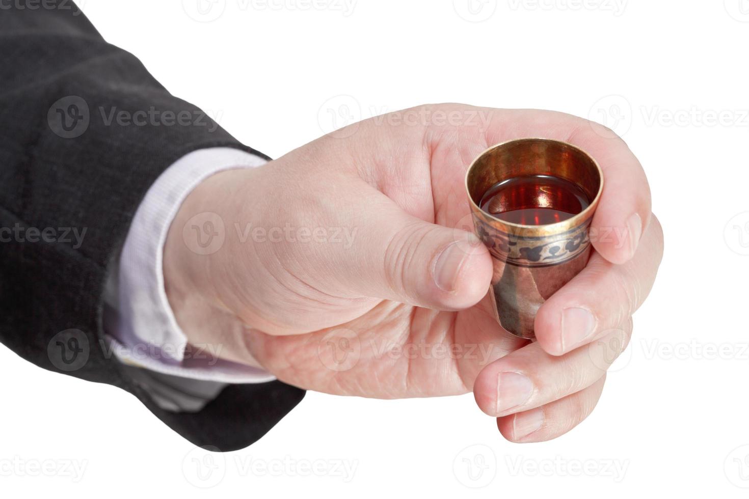 sweet liquor in silver glass in male hand photo