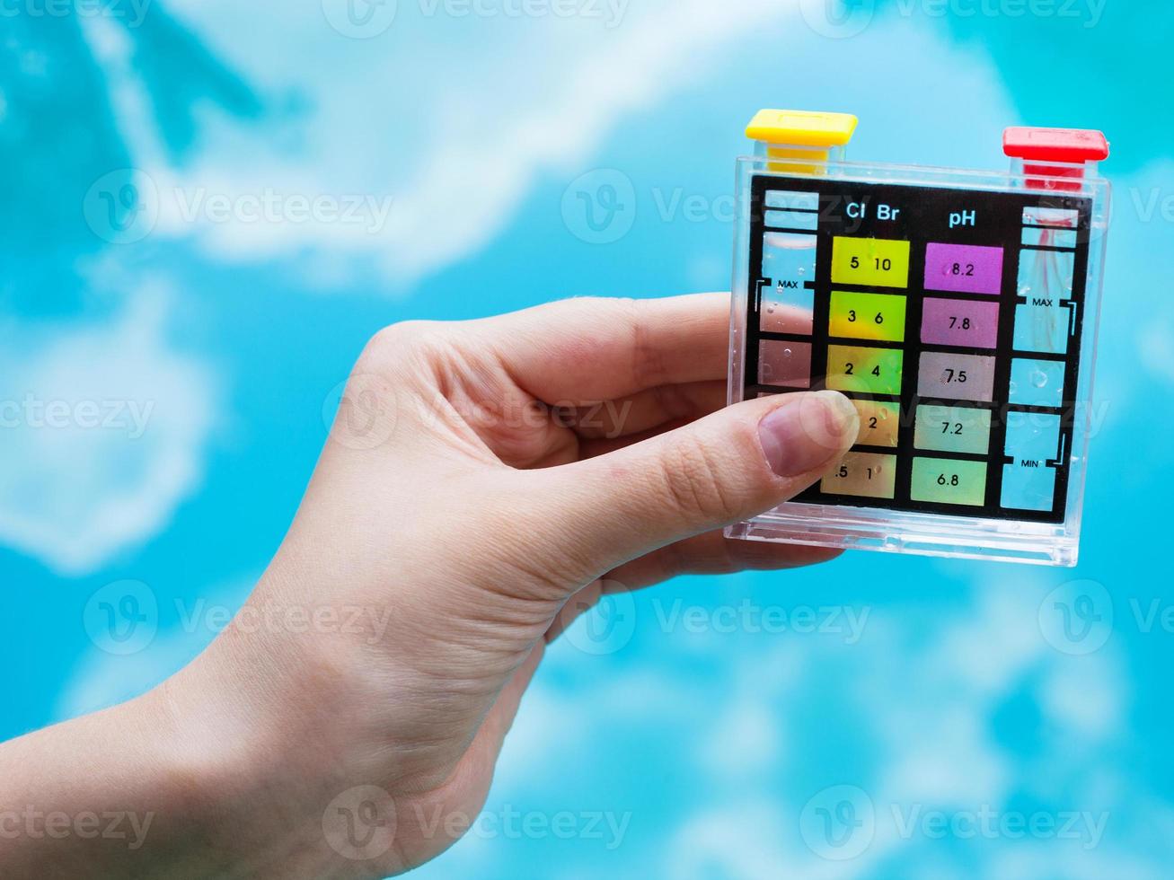 checking pH level in blue outdoor pool photo