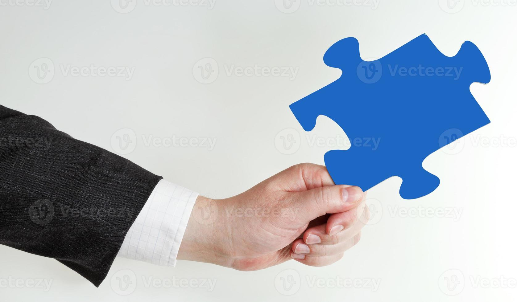 male hand holding blue puzzle piece photo