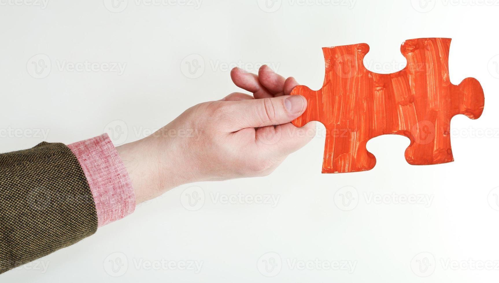red painted puzzle piece in male hand photo