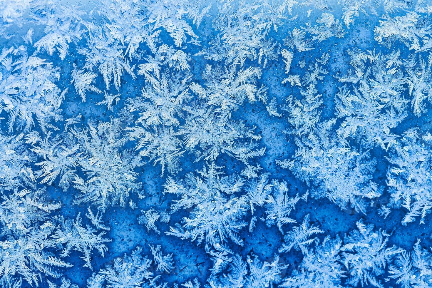 snowflakes and frost on window in winter close up photo