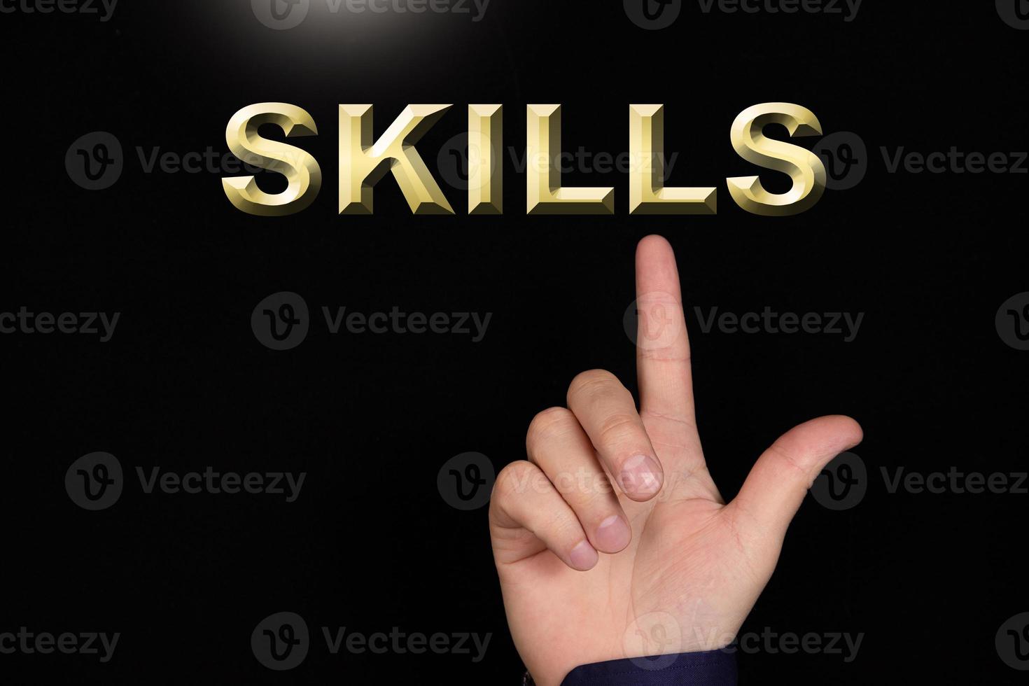 SKILLS text, a word written on a black background pointed to by a hand with the index finger of a person. photo