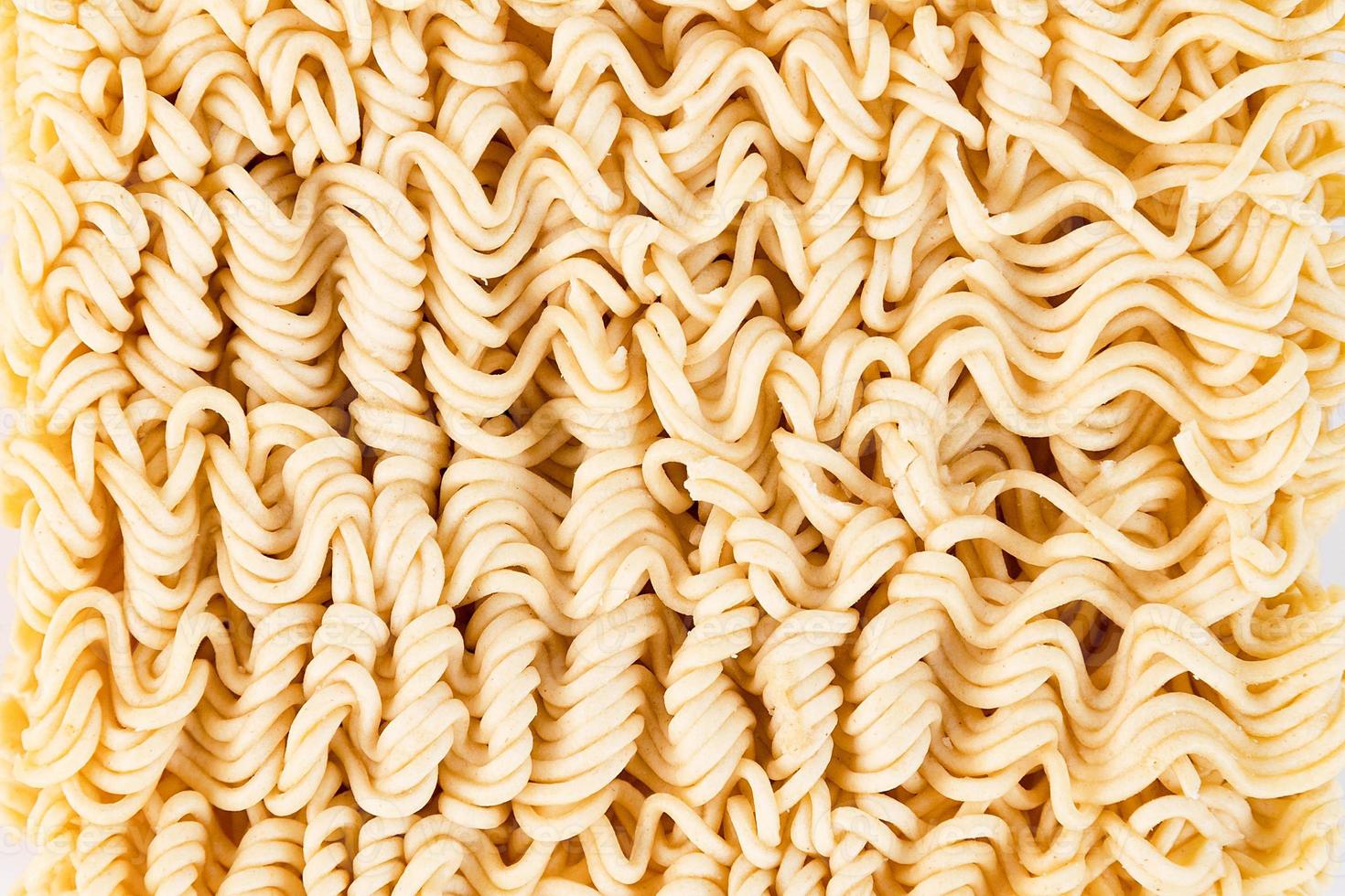 Dry instant noodles of yellow color, close-up. Texture, background. photo