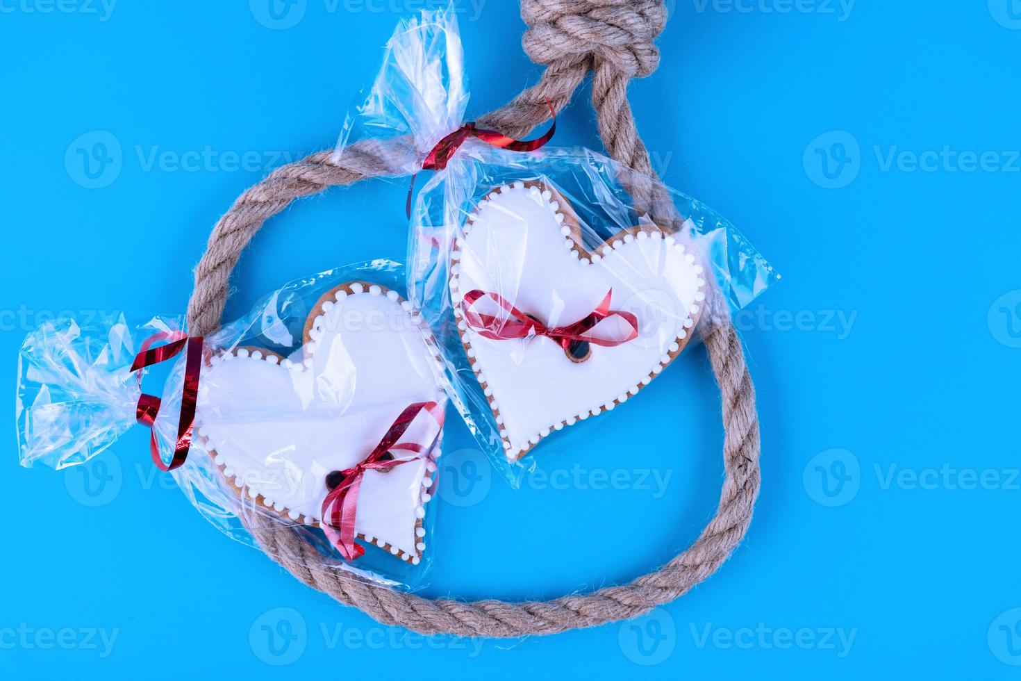 Valentine's Day cookies. Sweet biscuits in the form of a heart and a stranglehold, a loop. Homemade baking. View from above. Blue background. Copy space. photo