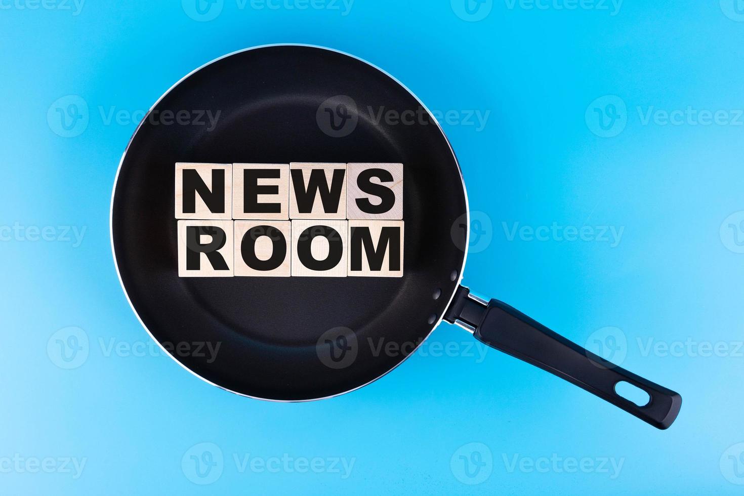 NEWS ROOM word, text written on wooden cubes, building blocks lying in a frying pan, and blue background. photo