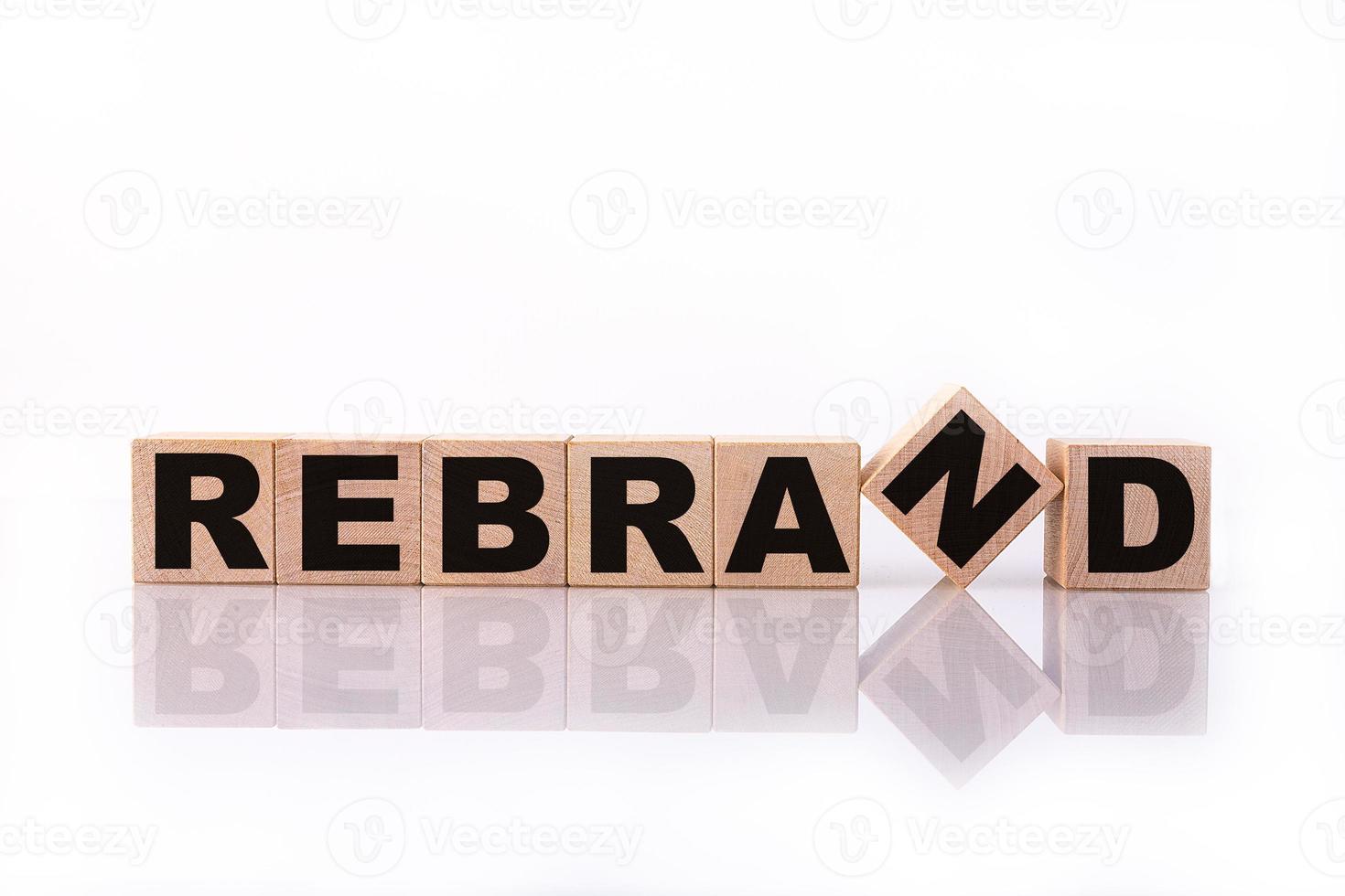 REBRAND word, text written on wooden cubes on a white background with reflection. photo