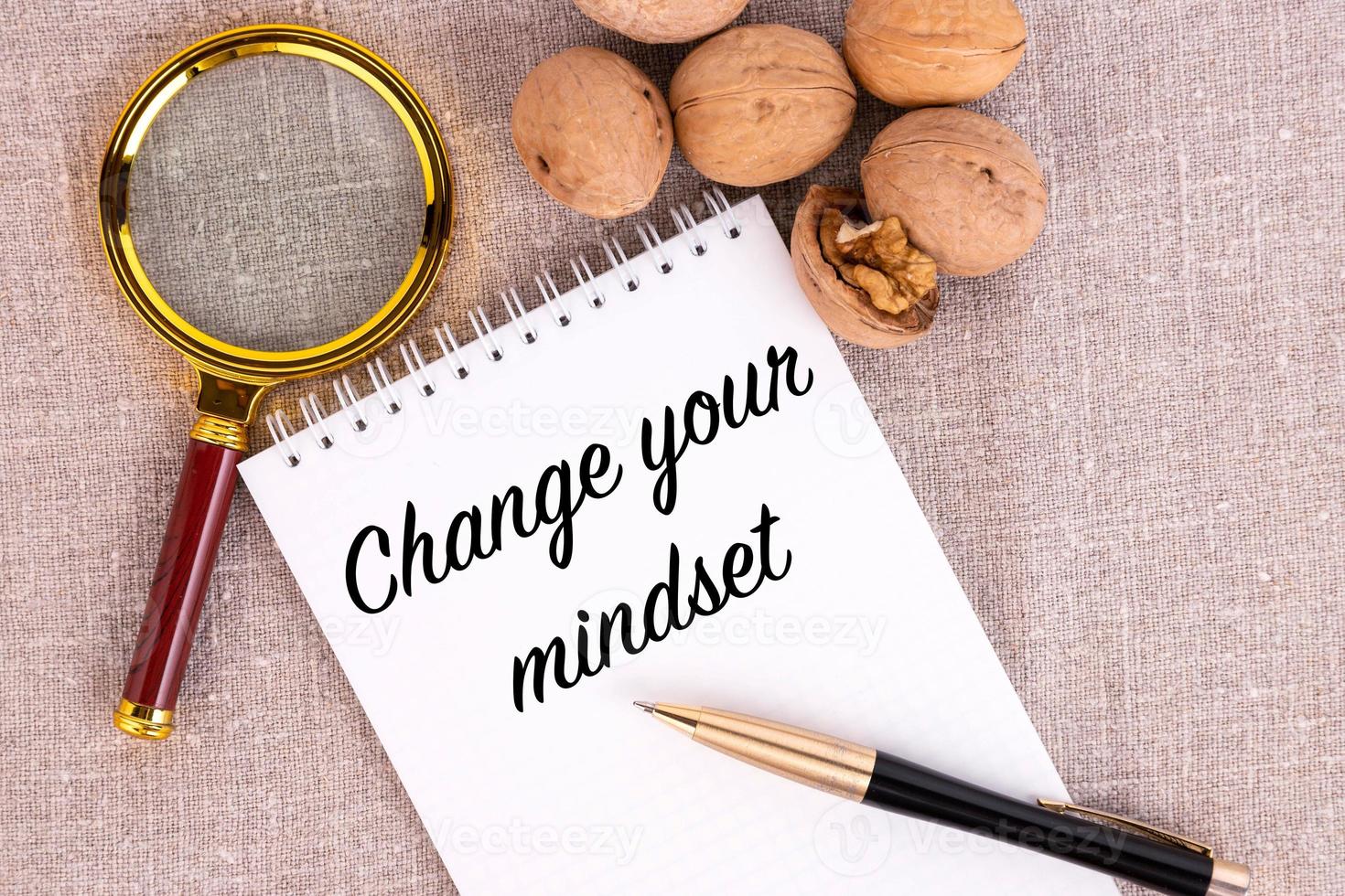 Change your mindset, the text is written in a notebook, there is a pen and walnuts next to it. photo