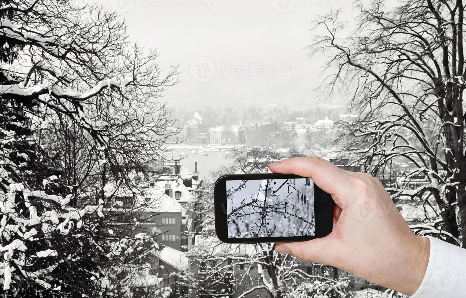 turista tomando fotos del horizonte de zúrich en invierno