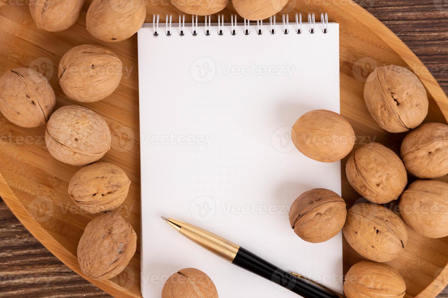 Walnuts and brainstorming, blank notebook on brown background, top view. A copy of the space. photo