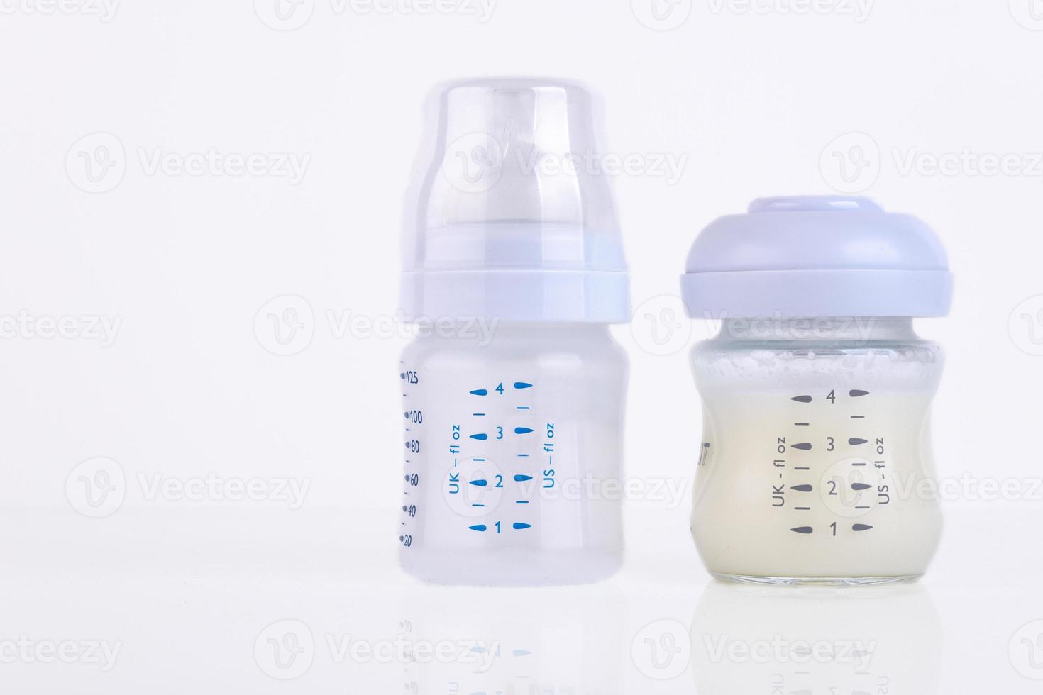 Baby bottle with pacifier and milk for feeding milk on a light background. Copy space. photo