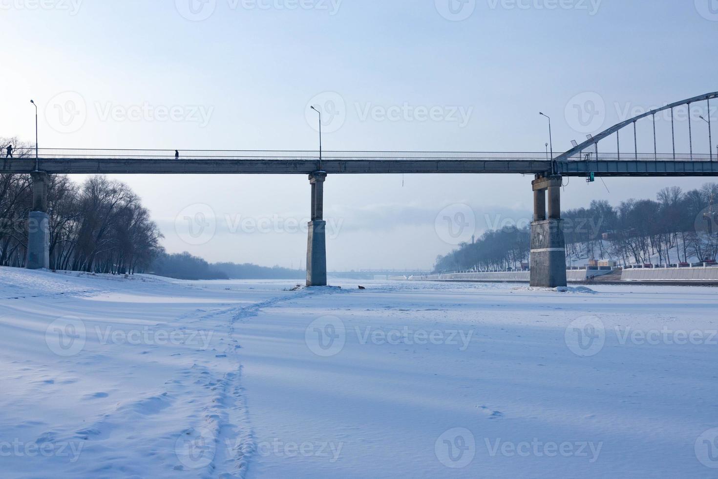 Winter landscape of ice-bound river with frost haze. photo