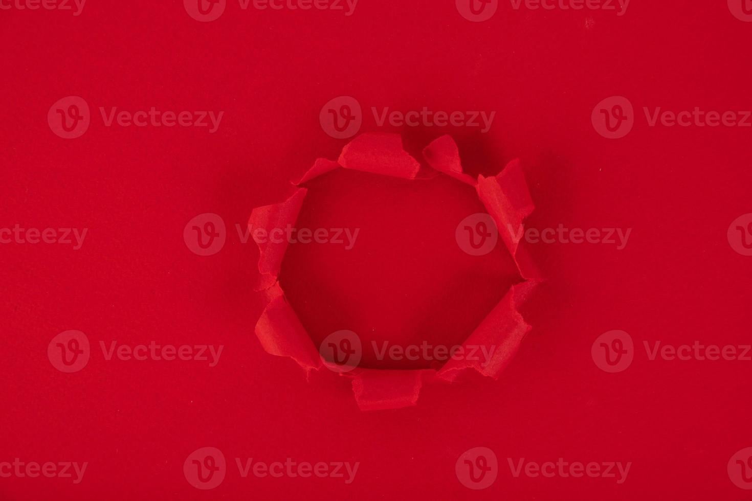 A red sheet of paper with a hole in the middle. reminder. Background, texture. Copy space. photo