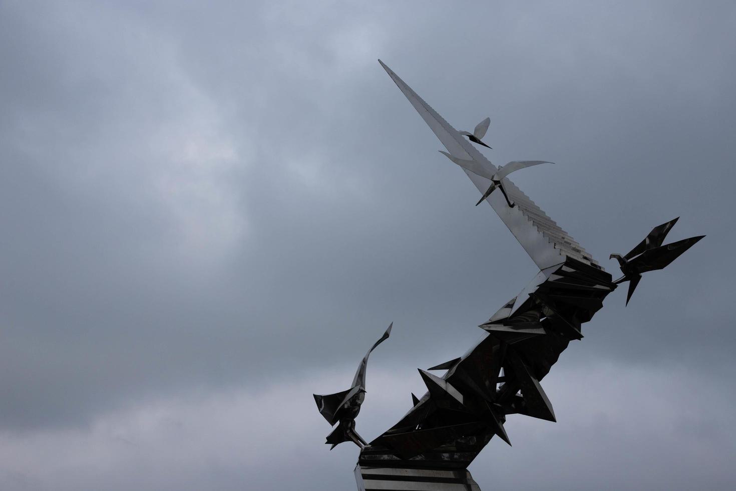 minsk, bielorrusia - 26 de octubre de 2020 - monumentos, arte contemporáneo, pájaros de metal de acero inoxidable en el río en otoño. foto