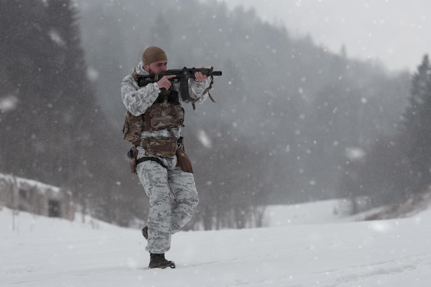 Winter war in the Arctic mountains. Operation in cold conditions.Soldier in winter camouflaged uniform in Modern warfare army on a snow day on forest battlefield with a rifle. Selective focus photo