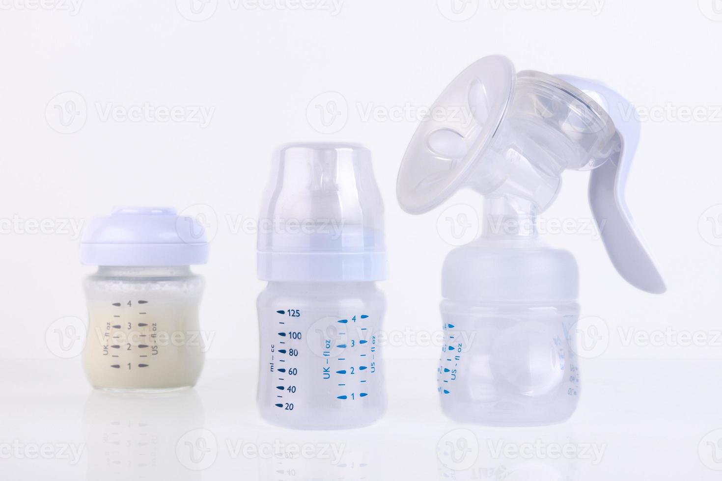 Baby bottle with pacifier and milk, for feeding milk and breast pump, on a light background. Copy space. photo